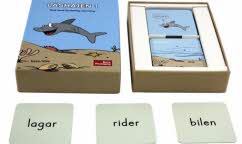 Bilden visar materialet till Läshajen 1. Visar spelkort från spelet med flera små kort med ord på.
